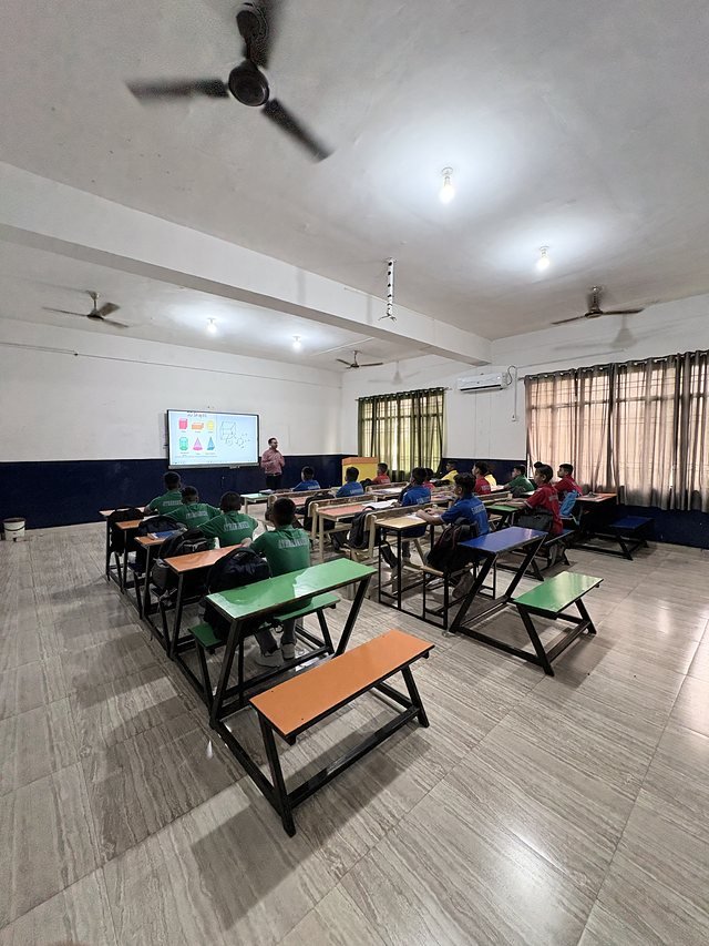 Classroom with rows of desks facing a smart display