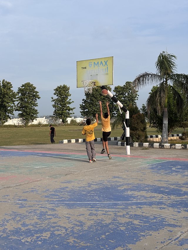 The outdoor multi-purpose court with school signage and palm trees