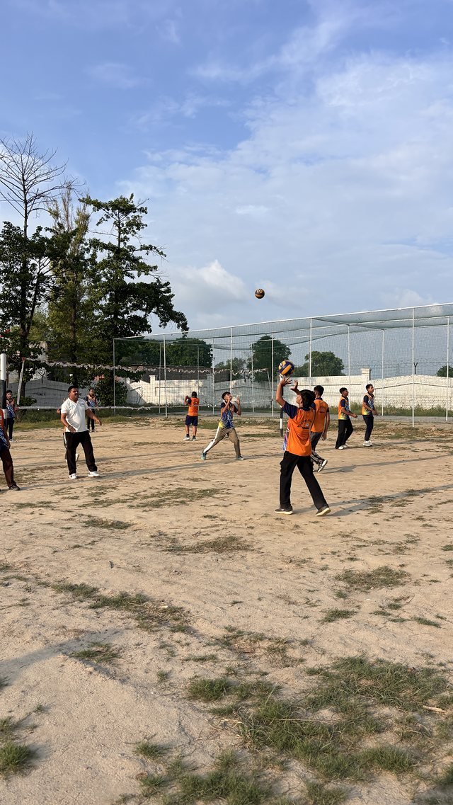 A volleyball team spread across the court during a match